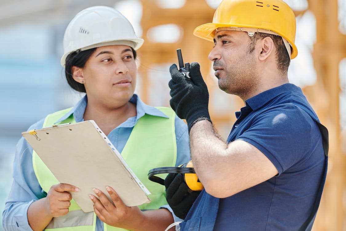Two construction professionals reviewing project plans at an active job site