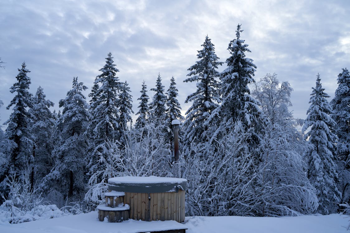 Outdoor hot tub steaming in a snowy winter landscape showing year-round enjoyment