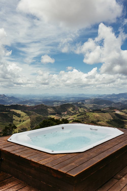 Hot tub on a scenic patio surrounded by lush greenery and outdoor living space