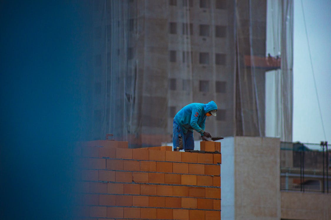 Skilled trade worker performing detailed masonry work on a construction site