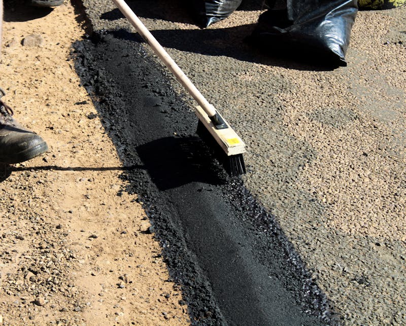 Professional concrete workers finishing a residential driveway surface with hand tools